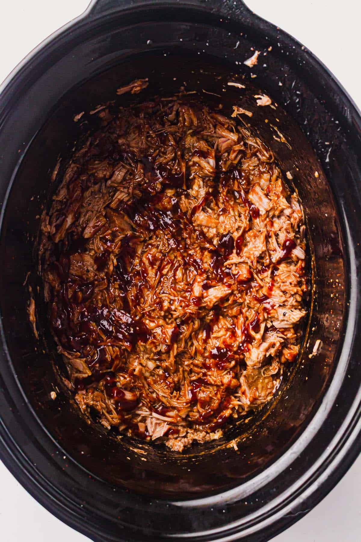 BBQ pulled pork mixed and simmering in the slow cooker