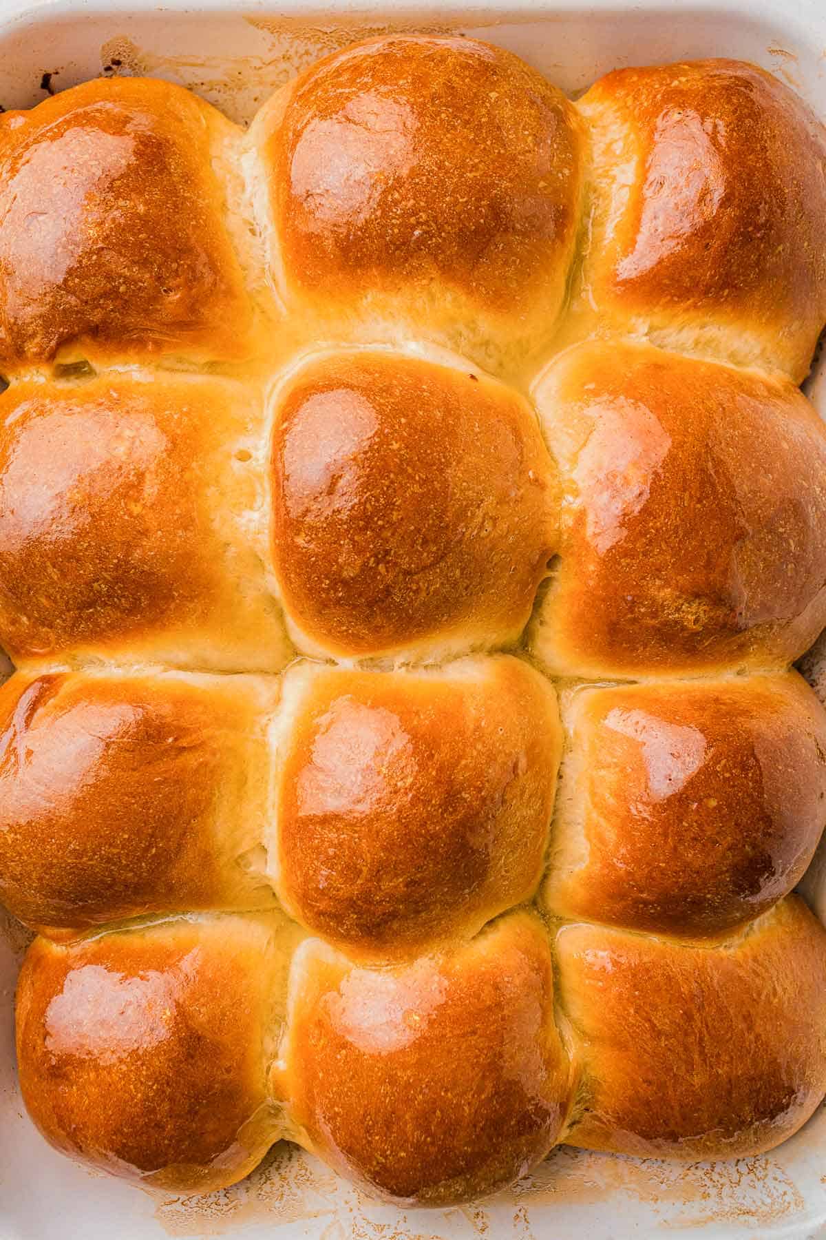 Golden homemade dinner rolls brushed with melted butter.
