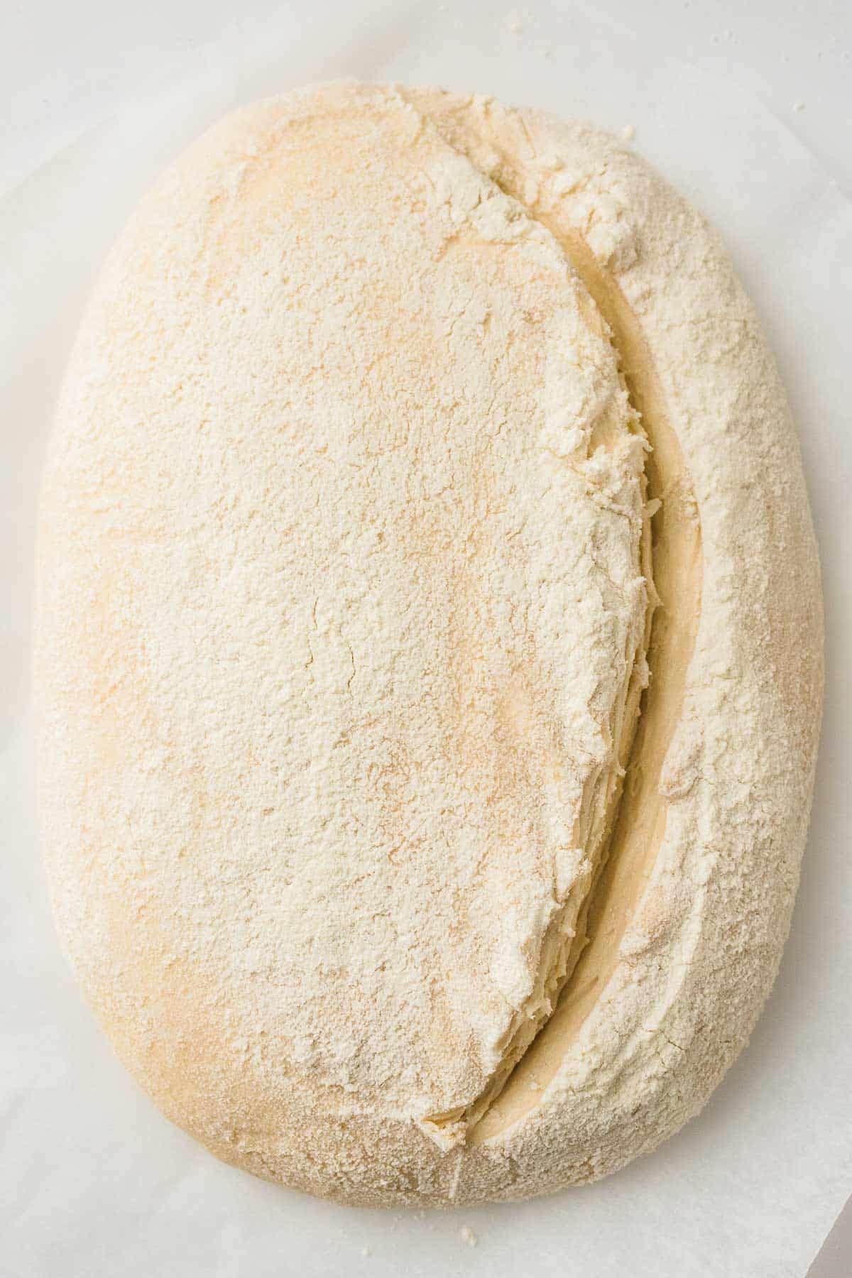 Scored sourdough dough ready to bake in a Dutch oven